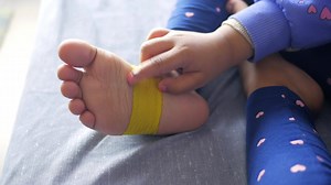 Download Elastic therapeutic yellow tape applied to child leg. for free