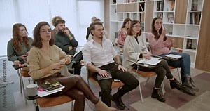 In a office classroom, a cross-generational group of business employees participates in a corporate business training or seminar, highlighting the importance of continuous learning and development.