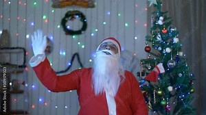 Old funny Santa laughing out loud in glass spectacles on Christmas Eve in India. Happy Santa Claus waving his hand while making a ho ho ho sound during Christmas celebration near a decorated Christ...
