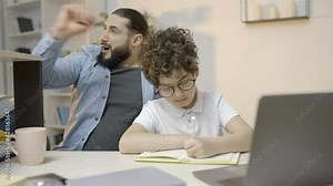 Bored father yawning controlling little son doing home assignment, studying