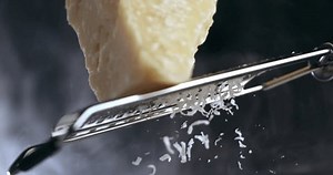 「プロのシェフが伝統的なパルメザンチーズと鉄のグラーターを料理の接写に使い、チーズの断片が1000 fpsで落下し、パスタを準備するという超スローモーションのマクロ。」の動画素材（ロイヤリティフリー）1110800639 | Shutterstock
