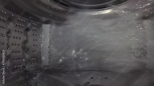 Washer, digital camera inside a rotating perforated drum. Internal view of a washing machine drum during washing process.