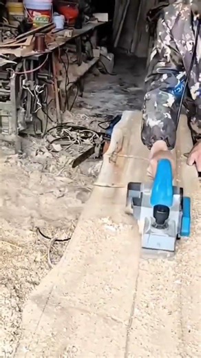Professional Woodworker Using Electric Hand Planer on Large Timber Slab