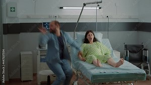 Young man panicking while pregnant wife having contractions in hospital ward. Caucasian husband getting medical assistance help for screaming wife in pain. Childbirth agony and ache