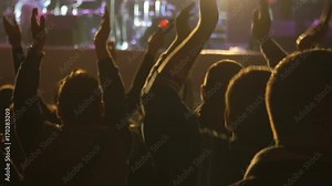 Footage of a crowd partying, dancing slow motion at a concert
