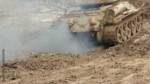 Two Armoured military Tanks driving through the mud. This Army vehicle is splashing. War / Battle scene