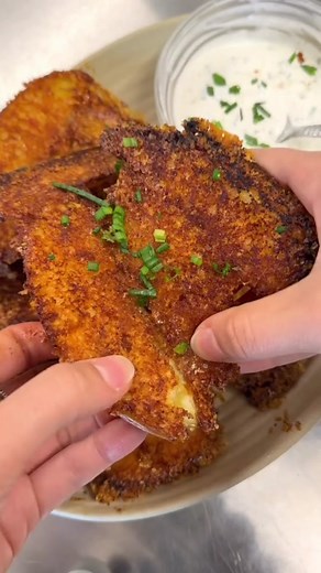 Our take on the viral crispy Parmesan potatoes! We used fingerling instead of baby potatoes, and served them alongside a garlicky sour cream sauce! #crispypotatoes #parmesancrustedpotato #dinnerly #easyfoodrecipe #recipesquickandeasy