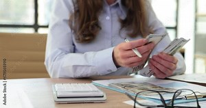 Closeup of woman counting money on calculator and holding of money