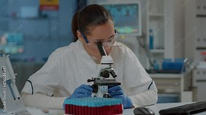 Microbiologist working with microscopic tool to research substance in laboratory. Chemistry engineer using microscope with optical lens and magnifying glass for scientific experiment in lab.