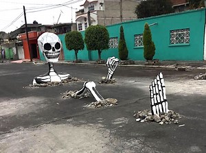 A Giant Skeleton Emerges From the Pavement of a Street in Mexico City During Día de Muertos