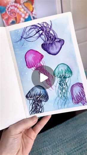 Andrea Nelson on Instagram: "I have painted more jellyfish than I can count over the years and it never gets old! My shirt is from @onelanestudios Supplies are my brand and are on my page. My watercolor sea creatures class is also on my page 🐳 🦈 🪼 Watercolor sketchbook 24 color essential palette 1 inch flat brush and size 6 round brush Artist tape Uniball signo gel pen #watercolortutorial #jellyfish #sketchbookideas #easyart"