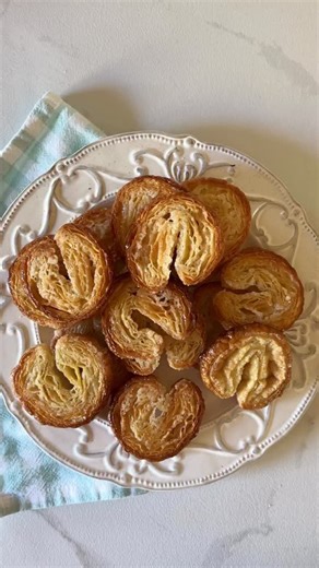 How to make Palmiers aka Elephant Ears - with just 3 ingredients! Originating in France, these classic pastries are made with just puff pastry, butter, and sugar — folded into their signature heart shape and baked until caramelised, golden, and crisp. Ingredients: • 400g frozen puff pastry (defrosted overnight in fridge) • 2–3 tbsp melted salted butter • ¾ cup sugar (approx.) Directions: - Sprinkle sugar over your surface, place down the pastry sheet and sprinkle more sugar on top. Roll gently t