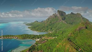 Capturing breathtaking aerial views of Bora Bora, featuring iconic mount Otemanu, lush green slopes, and crystal-clear turquoise lagoon waters