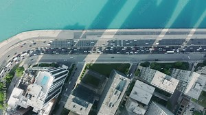 Bird-eye view on rooftops of the waterfront residential apartment buildings in Chicago downtown. 4K aerial top-down view on busy traffic road in Chicago district. Expensive real estate in skyscrapers