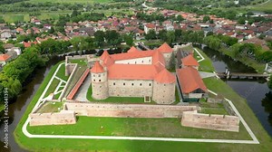 Cinematic aerial perspective of Fagaras City. Drone forward passing above Făgăraș Citadel. Beautiful panoramic view of all city of Fagaras. The fortress was a prison for political detainees.
