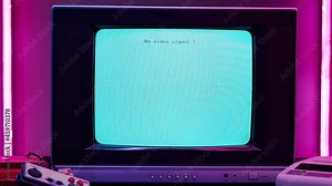 Old television with blue screen on pink neon background. Close-up of vintage tv and cartridges for retro playstation. Antique video game, nostalgia.