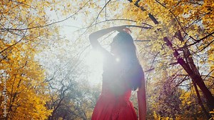 Beautiful woman running in a red dress in the park
