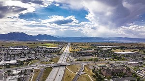 Highway traffic with mountains and rain clouds, aerial hyperlapse, Superior, Colorado, 4K
