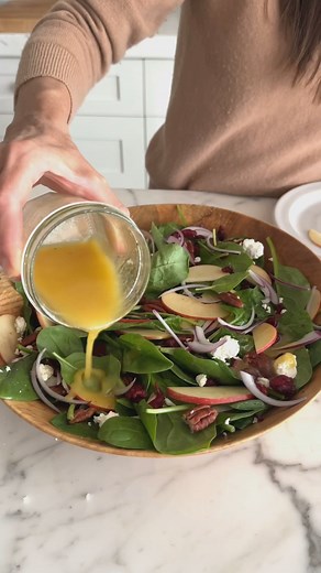 This spinach salad recipe is simple, fresh, and tastes like fall. It's the perfect dish to brighten up your Thanksgiving meal! Ingredients: * 5 ounces fresh spinach * 1 Gala or Honeycrisp apple, thinly sliced * ⅓ cup thinly sliced red onion * Apple Cider Vinegar Dressing * 1 heaping cup Candied Pecans * 2 ounces crumbled goat cheese or ¼ cup shaved pecorino cheese * ⅓ cup dried cranberries * Sea salt and freshly ground black pepper Instructions: * In a large bowl, place the spinach, apple, and o