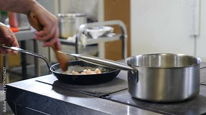 Close up. Restaurant kitchen concept. Kitchen staff cooperating. Tossing, pouring oil, stirring. Chef busy working. Shot in 4k