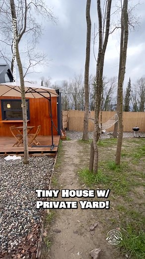 Would you live in this foundation tiny house with a private yard? One of my favorite cozy spaces! Inside, this tiny house features an open floor plan including a linear kitchen with the essentials to cook most meals (just missing an oven), a living room with a cozy couch & a projecter, a bathroom with a beautiful tile shower, a lofted bedroom, a dining nook for two, & a beautiful outdoor living setup with a deck & hammock! #tinyhouse #tinyhome #airbnb #housetour #hometour | Alan Toscano