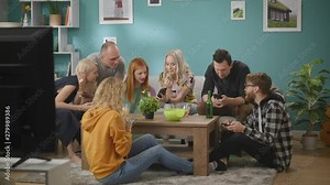 Young friends sitting at sofa and using their phones all time during home party