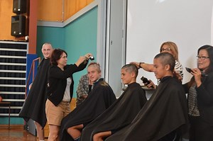 High school students shave their heads in front of school