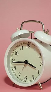 Download Vertical time lapse of a clock time passing over a day to night on pink background. for free
