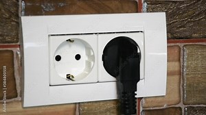 European double power socket. Plugging and unplugging the device by a a woman.