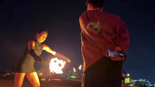 Fire dancer lights cigarette during performance in Hainan, China