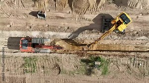 Top view video of two backhoes working together excavating a trench in a construction site