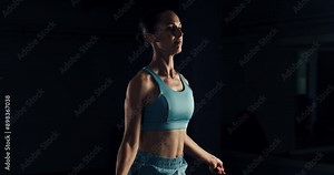 Super slow motion close up of female athlete is doing workout by skipping rope to maintain healthy lifestyle and bodybuilding fitness goals in a gym at 1000 fps.