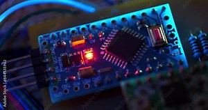Microcircuit with electronic components connected to power supply. Electronic circuit with burning red LED light bulb, zoom-out video