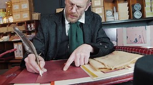 Premium stock video - Ebeneezer scrooge close up ans he does his accounts