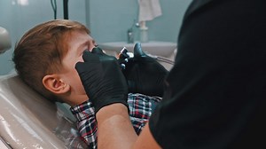 Scared little boy getting his teeth done with the dentist - Free Stock Video