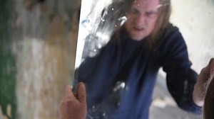 Download Depressed and angry man is holding a mirror and looking at it angrily for free