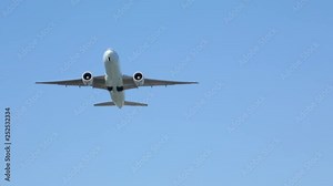 Twin engine jet plane airplane aircraft at takeoff flying overhead in blue sky