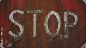 Stop sign. Old shabby and rusty road sign. Entry into the forbidden zone. Abandoned road. The order will stop. A shabby stop sign before entering the abandoned city. 4K (UHD). 2 shots