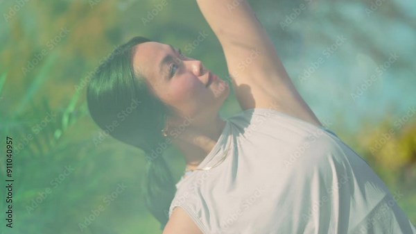 Young asian woman doing yoga poses. stretching and breathing exercises in garden conservatory, sunny day, nature, natural light. Mid shot dynamic jib movement gimbal slow motion through window
