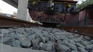 View from underneath a train toward the end of the train carrying people in Thailand. Underneath view of train in motion.