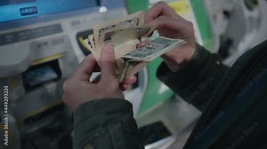 Hands Counting Japanese Yen Bills Before Sending Through Furikomi (Bank Transfer) Machine In Sendai, Japan. close up