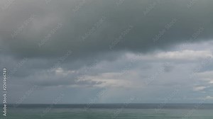 Rain clouds move very quickly over the horizon on the sea or ocean time lapse