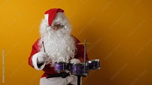 Santa Claus plays on a drum set.