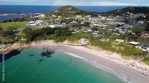 Bicheno, Tasmania: Aerial drone footage of the beach at Bicheno coastline with a rainbow close to the famous Coles bay in Tasmania in Australia. Shot with a tilt up motion