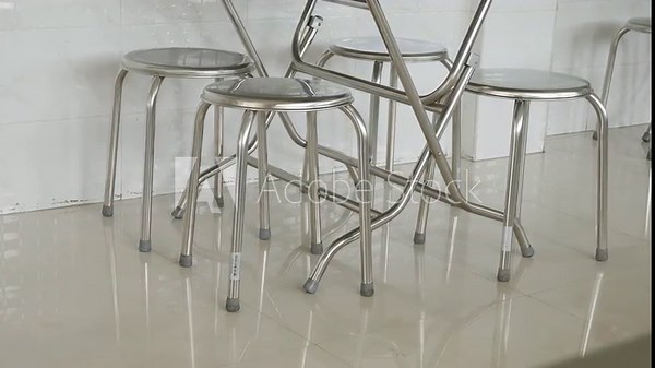 stainless steel round stools and folding tables in a clean modern Asian restaurant