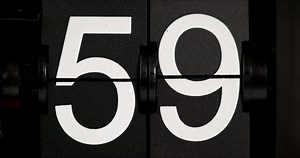 Flip clock Vintage countdown white numbers fifty-nine turn zero zero on black background.