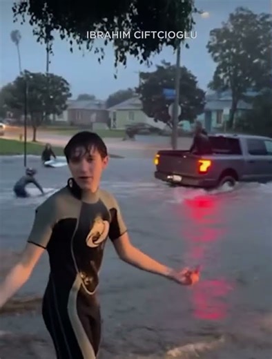 Kids take on street surfing in flooded neighborhood