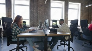 A diverse group of colleagues collaborates using laptops, mobiles, and tablets to tackle business challenges and enhance productivity through teamwork and innovative technology. Stock Video