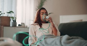 Woman, sick and respiratory illness with nebulizer, health and wellness for medical condition in home. Female person, virus and oxygen mask for pneumonia, asthma and recovery in lounge for healing