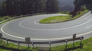 A rural highway road as it curves up a hill